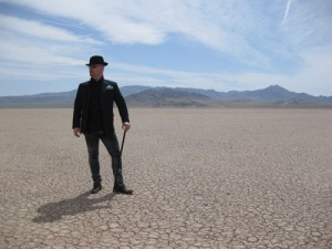 Vreny in the scorching desert posing with cane and bowler hat