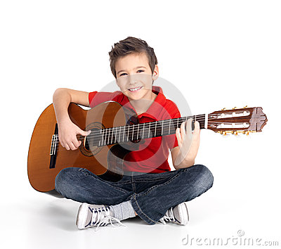 a stock photo of a laughing kid playing guitar