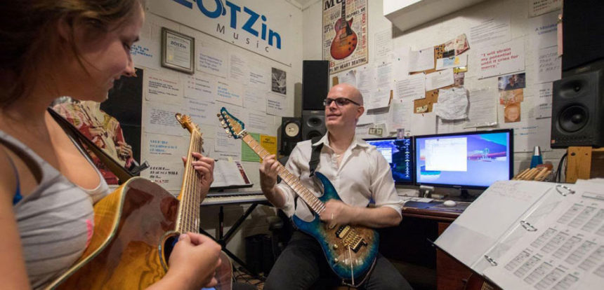 Vreny Van Elslande teaching a student guitar at the ZOT Zin Music studio
