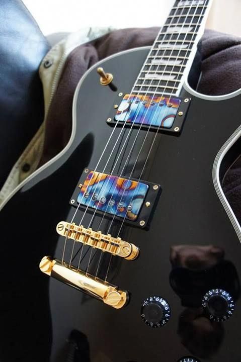 This Black Les Paul with white binding and gold harware looks lovely. Love the specially painted humbucker covers