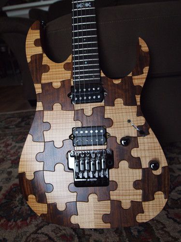 This extraordinary Strat type guitar is made of pieces of wood that are shapes into puzzle pieces, which put together form this guitar body