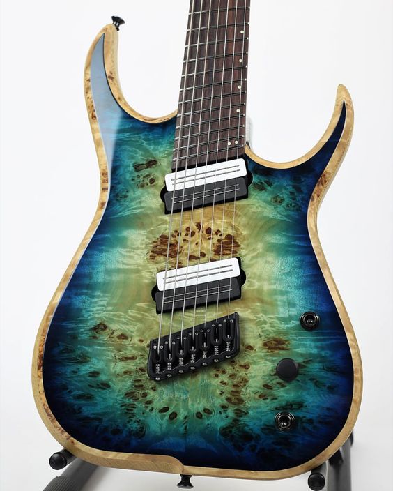 This gorgeous blue to green to yellow burst 7-string guitar has amazing burl wood, and a beautiful natural wood-colored binding