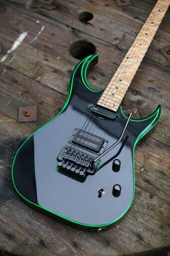 The light colored maple neck offers a beautiful contrast against the black and fluo green guitar body