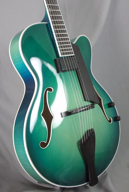 A gorgeous deep teal green-ish jazz hollow body guitar
