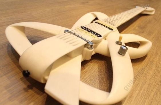 a must see creamy white guitar, in the shape of a band that is in a knot. 