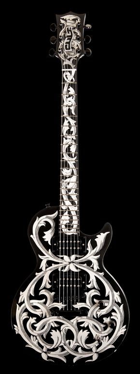 Black guitar with swirling, white grey-ish floral print all over the guitar body and neck. 
