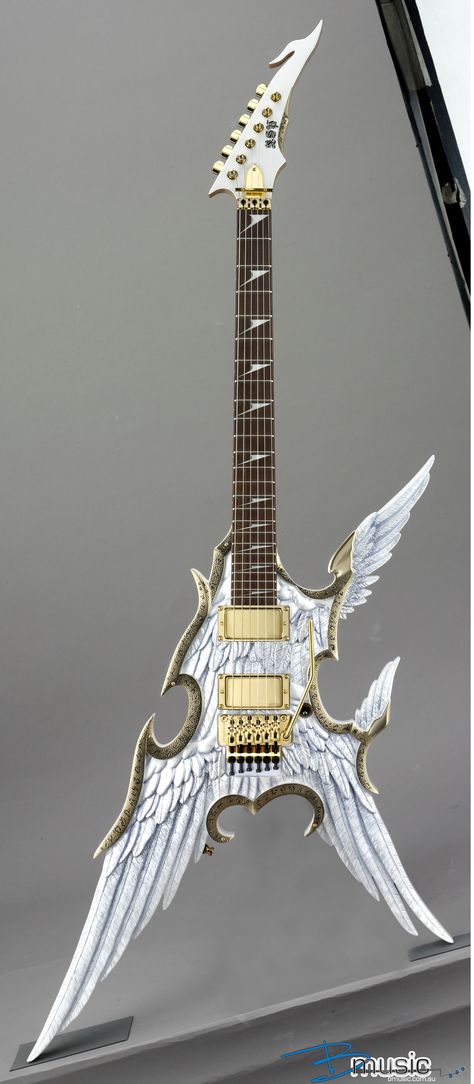 A white Flying V shapes guitar with the V corners turned into carved feathers. 