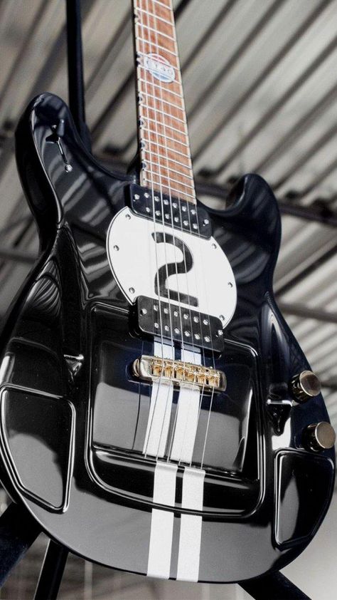 black guitar, the number 2 in a white circle, white stripes, the bridge looks elevated as if mounted on a hood
