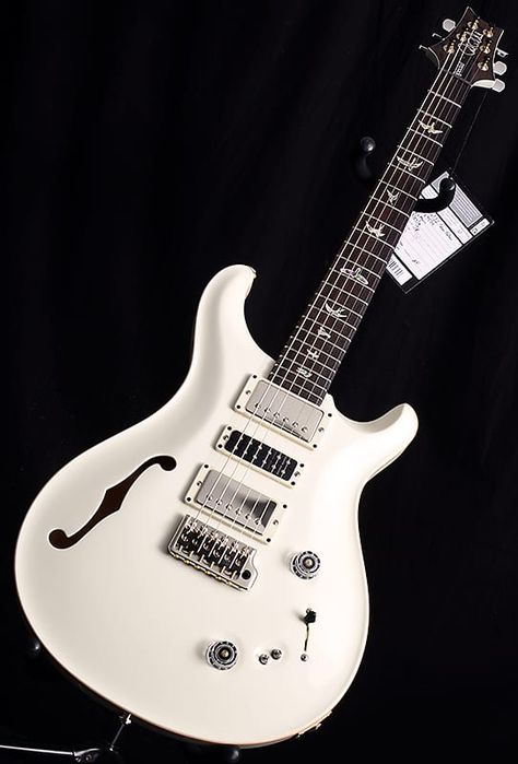 White and chrome PRS style guitar with F hole