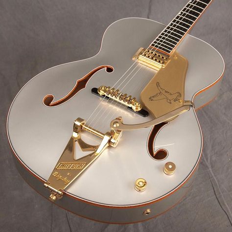 A classy guitar: light silver colored body with gold hardware and f holes